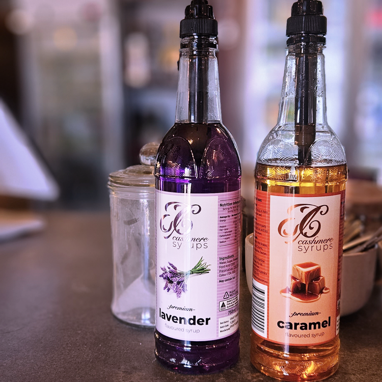 Cashmere Syrups Lavender Syrup and Caramel Syrup bottles fitted with pumps on a café counter